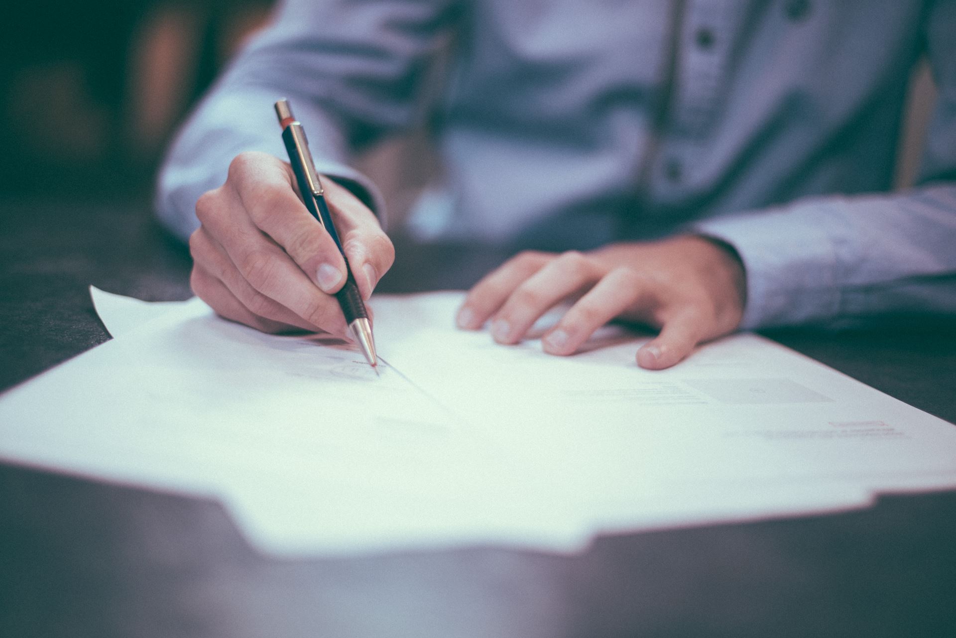 a person writing at a table